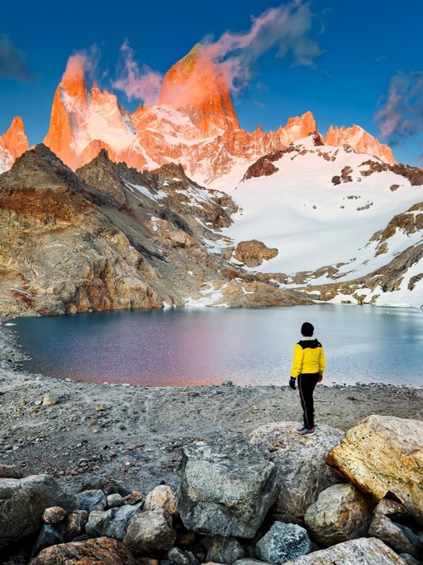 Viajero frente a la Laguna de los Tres con el cerro Fitz Roy iluminado al amanecer